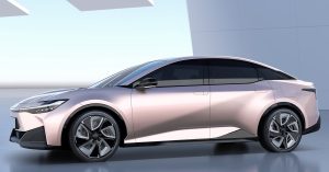 Side view of a sleek, pink electric vehicle with distinctive wheels and modern design.