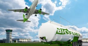 An airplane is flying above a biofuel tank on an airport runway.