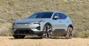 Polestar 3 in a natural setting, showcasing a front angle, sleek design, and large wheels.