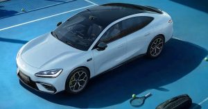 White electric vehicle viewed from above, showcasing sleek design and sporty wheels.