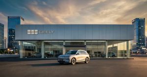 Silver Geely SUV parked outside a modern showroom, showcasing sleek design and urban setting.