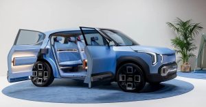 Side view of a blue Kia EV2 with open doors, showcasing interior seating and unique wheel design.