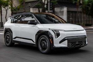 The Kia EV3 is shown from the front, featuring sleek headlights, black accents, and alloy wheels.