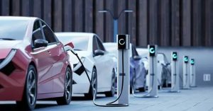 Red and white electric vehicles charging at stations in a modern outdoor setting.