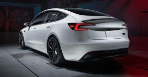 White Tesla Model 3 viewed from the rear, featuring sleek design and black wheels.
