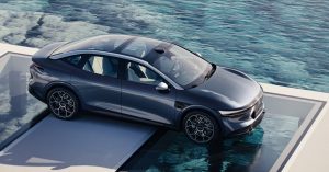 The image shows a Zeekr EV parked on a platform by water, featuring sleek lines and alloy wheels.