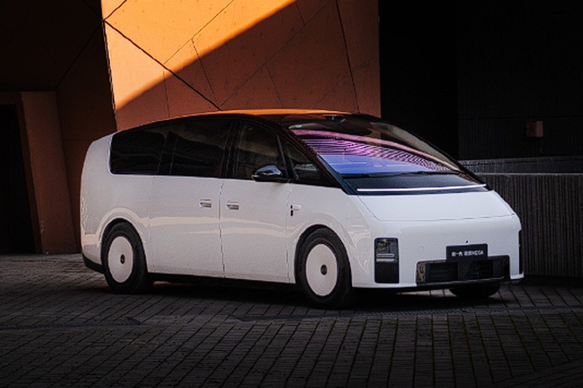 White electric vehicle shown from the front, featuring smooth lines and circular wheels.