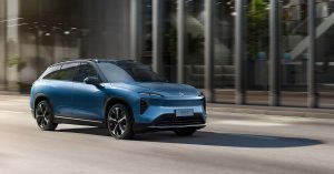 Blue Nio ES7 SUV in motion, showcasing sleek design, large wheels, and modern front grille.