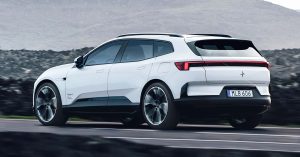 White Polestar 4 SUV driving on a road, showcasing sleek design and large wheels.
