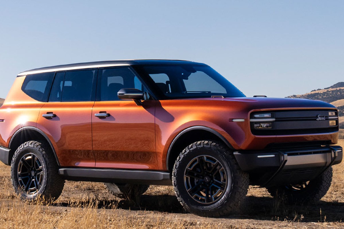 The SUV is shown from a side angle, featuring rugged tires, a glossy orange finish, and a modern design.