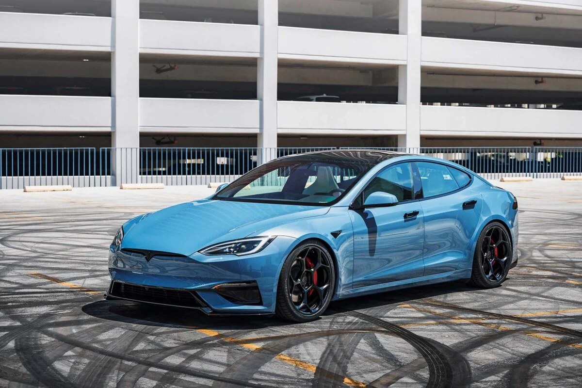 Blue Tesla Model S parked in a lot, showcasing large black wheels and sleek design.