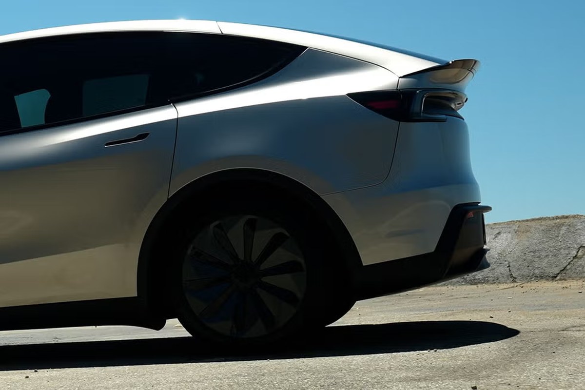 Silver Tesla Model Y viewed from the rear, showcasing sleek design and distinctive wheel.