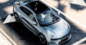 Silver electric vehicle viewed from above, showcasing sleek design, large wheels, and panoramic roof.