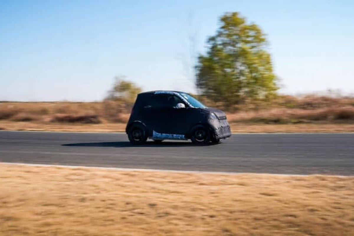 The Geely Smart #2 is seen in motion on a road, featuring a compact design and black camouflage.