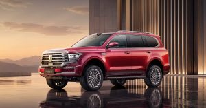 Red SUV with a prominent grille, alloy wheels, and sleek design in a showroom setting.