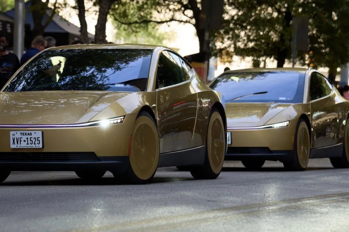 Two gold-colored Tesla vehicles parked on a street, showcasing sleek designs and modern headlights.