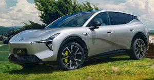 Silver Xpeng Mona L05 parked on grass, showcasing sleek design and distinctive wheels.